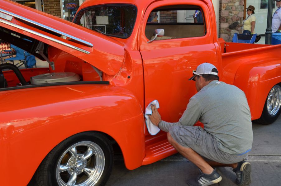 A Ford truck owner polishes the outside of his truck.