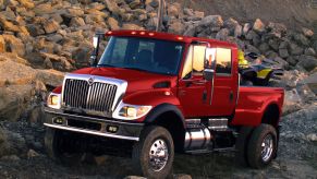 An International MXT truck driving over some rocks.