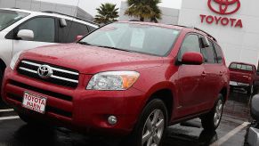 A red Toyota RAV4 on display at a car dealership.