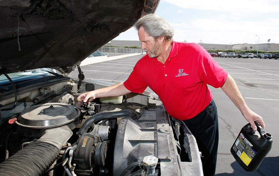 Man working on his Chevy Silverado 1500 changing the oil