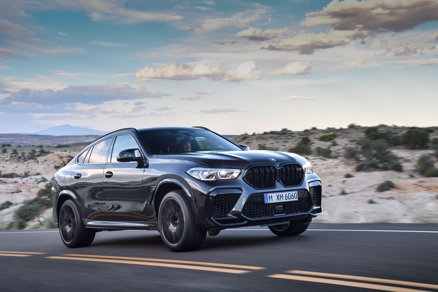 a 2020 MBW X6 M driving at speed on a gorgeous and desolate desert road 