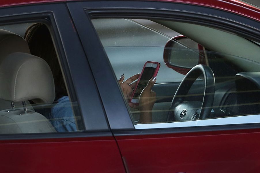 A bad driver using a phone while behind the wheel of a car