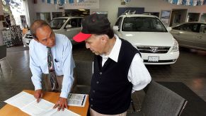 A car salesman going over the awards a car has won with a customer