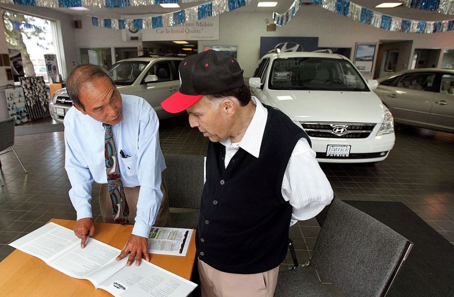 A car salesman going over the awards a car has won with a customer