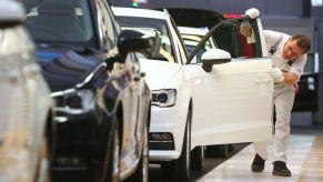 A person inspecting a car in the factory