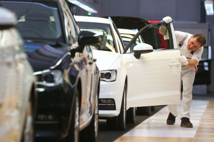 A person inspecting a car in the factory