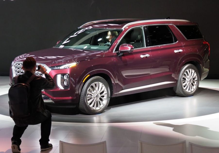 A man snaps a photo of a Hyundai Palisade