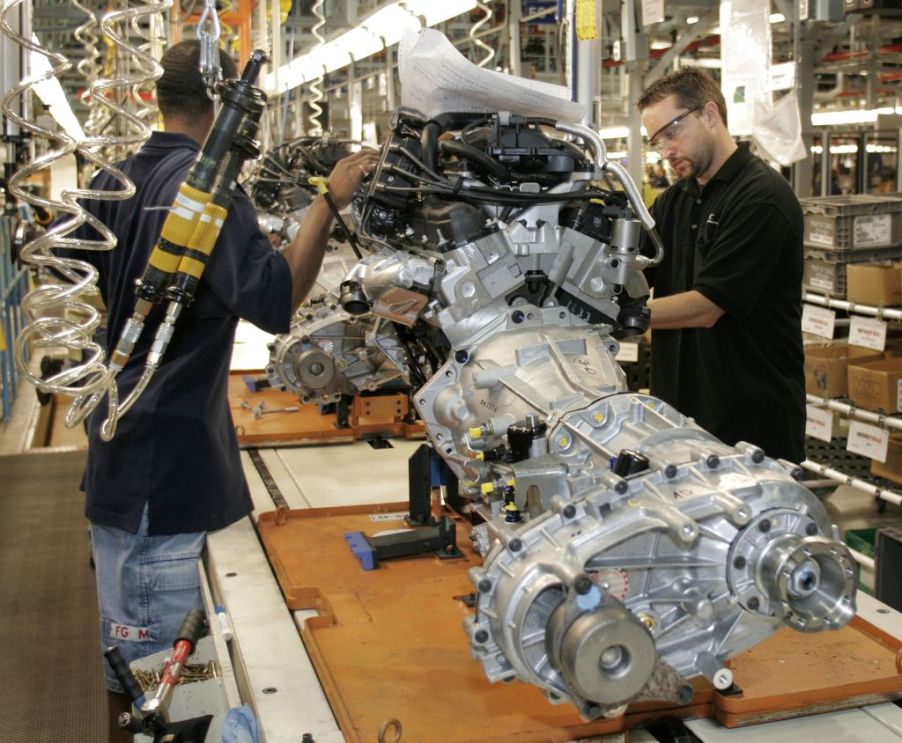 Assembly line workers do final inspection on a Jeep Wrangler engine