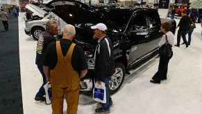 People walking around a Ram 1500 to inspect it