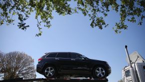 An SUV loaded to the top of a transport truck