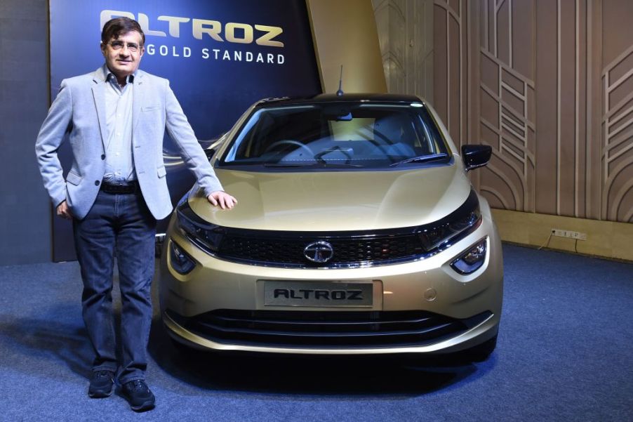 The President of Tata Motors stands next to one of the company's cars