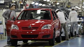 Workers inspect Toyota Corollas at a factory