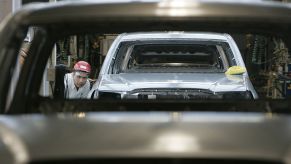 Workers assemble Toyota trucks in a factory