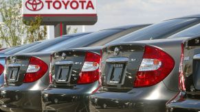 Toyota cars lined up in a dealership's parking low