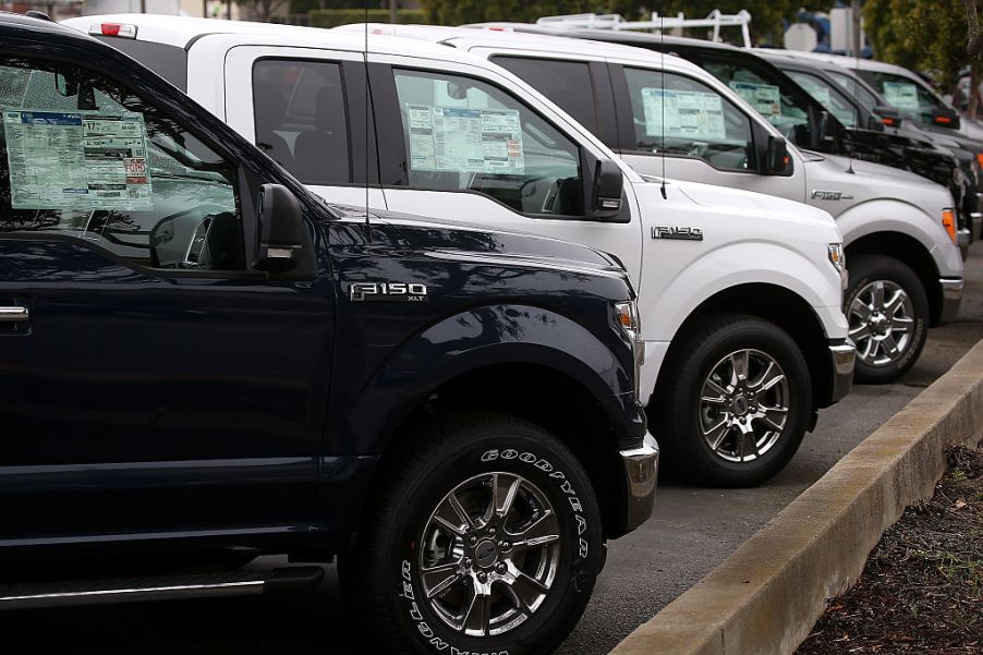 Ford F-150 pickup trucks lined up on a sales lot