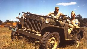 Two soldiers riding in a Willys Jeep