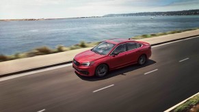 A red 2020 Subaru Legacy Sport cruising down the highway.