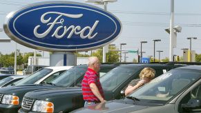 A pair of shoppers looking at new cars