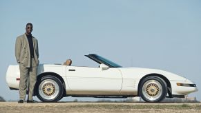 A portrait of Olympic and IAAF World Championship Gold medal wiinning 200 metres and 400 metres sprinter Michael Johnson of the United States standing alongside his Chevrolet Corvette C4 Coupe