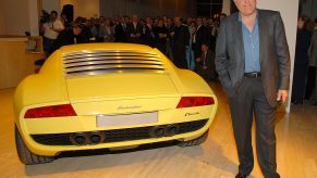 Jay Leno posing next to a Lamborghini Miura concept car