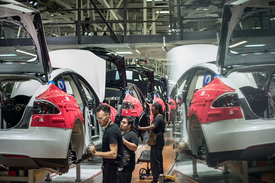 A worker assembles Tesla cars in a factory