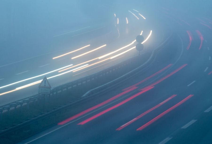 Vehicles are driving in the morning in fog