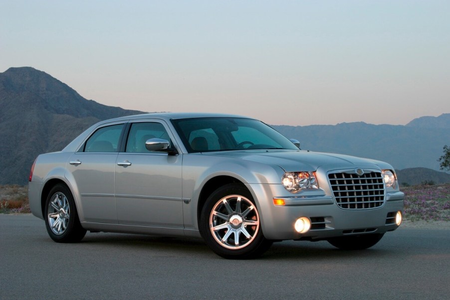 A silver 2006 Chrysler 300 shows off its lines with its lights on.