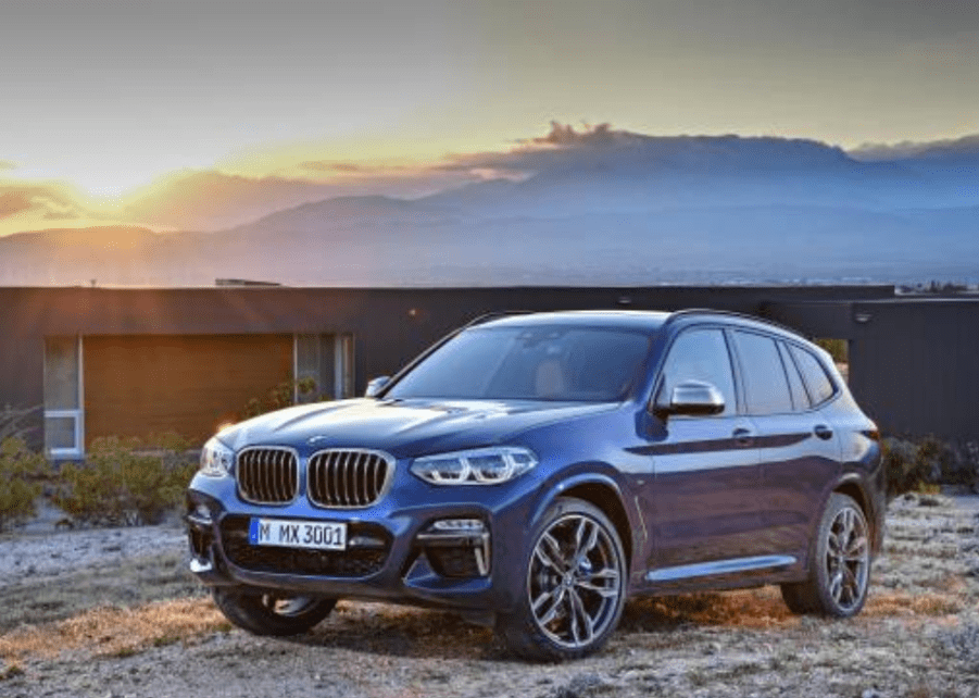 A blue 2021 BMW X3 at sunset.