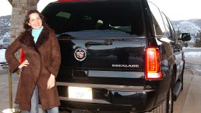 A women standing next to a Cadillac Escalade