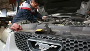 A mechanic working on a Ford Mustang