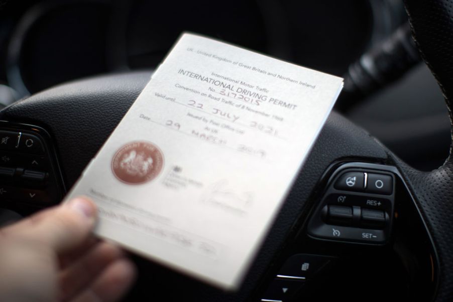 An International Driving Permit placed on top of a steering wheel.