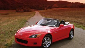 Red 2000 Honda S2000 with the top down on a back-country road