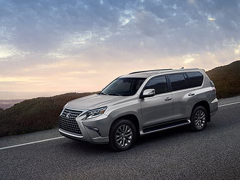 Lexus GX driving down road at dusk