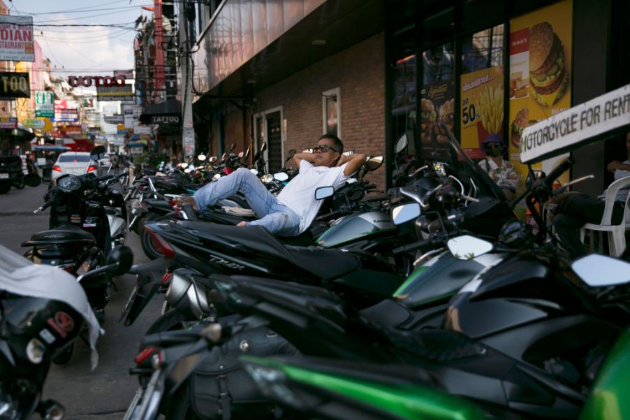 A man reclines at a spot for motorbike rentals