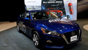 A blue Nissan Altima on display at an auto show