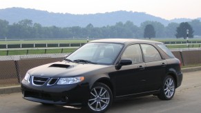 A black 2005 Saab 9-2X parked off of a scenic highway.