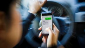 Woman sending a text message while driving a car