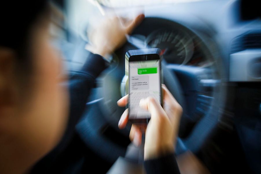 Woman sending a text message while driving a car