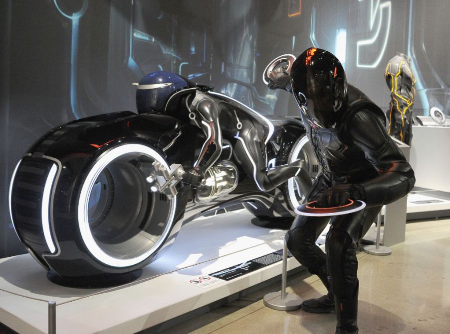 John Stiff as Rizzler/Tron poses along a LightCycle from 'Tron: Legacy' on Cosplay Day at The Petersen Automotive