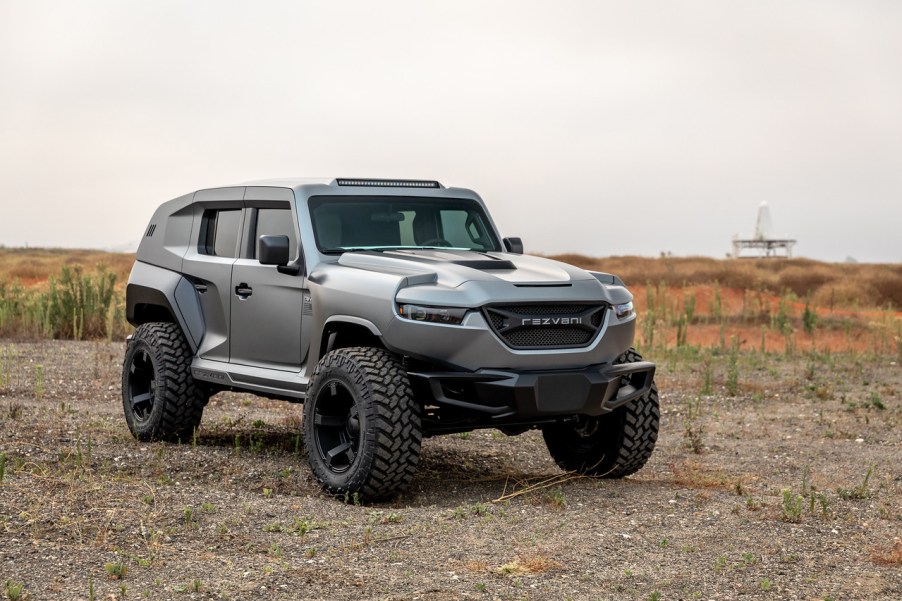 Gray Rezvani Tank SUV in a rocky desert field