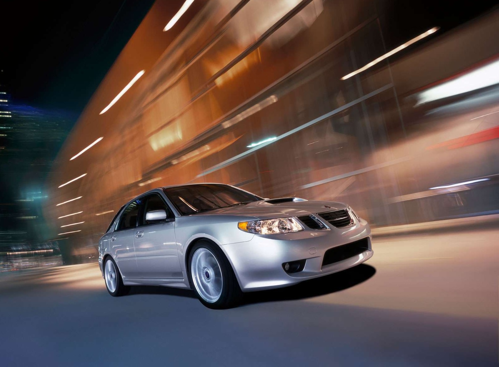 A silver 2005 Saab 9-2X driving at night