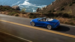 a blue lexus convertible cruising along a scenic seaside roadway