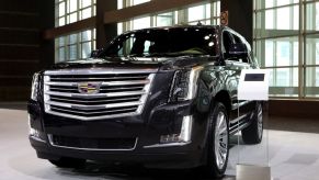 A black Cadillac Escalade on display at an auto show