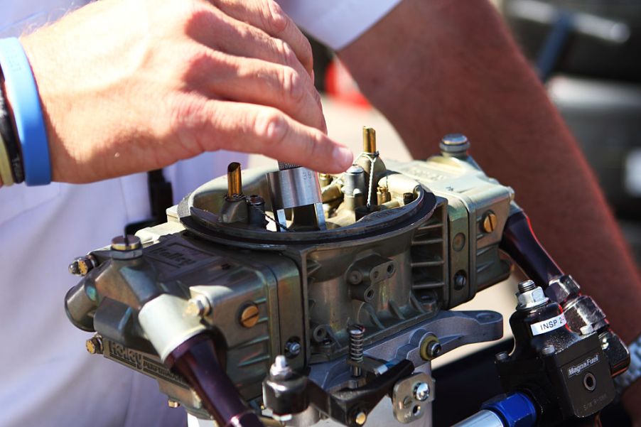 A NASCAR Official inspects a carburetor