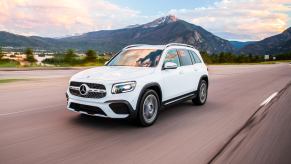 a white Mercedes-Benz GLB250 at speed on the an open country road.