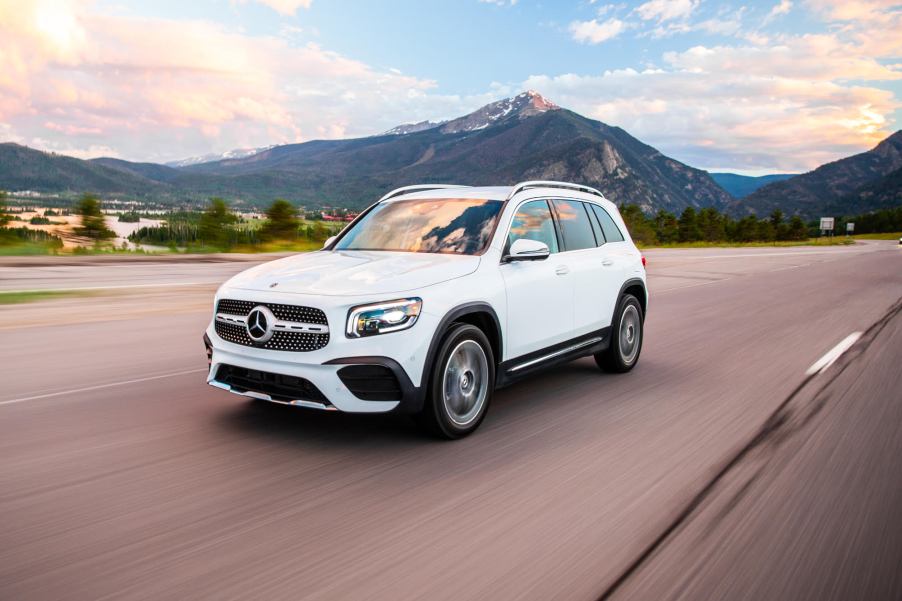 a white Mercedes-Benz GLB250 at speed on the an open country road.