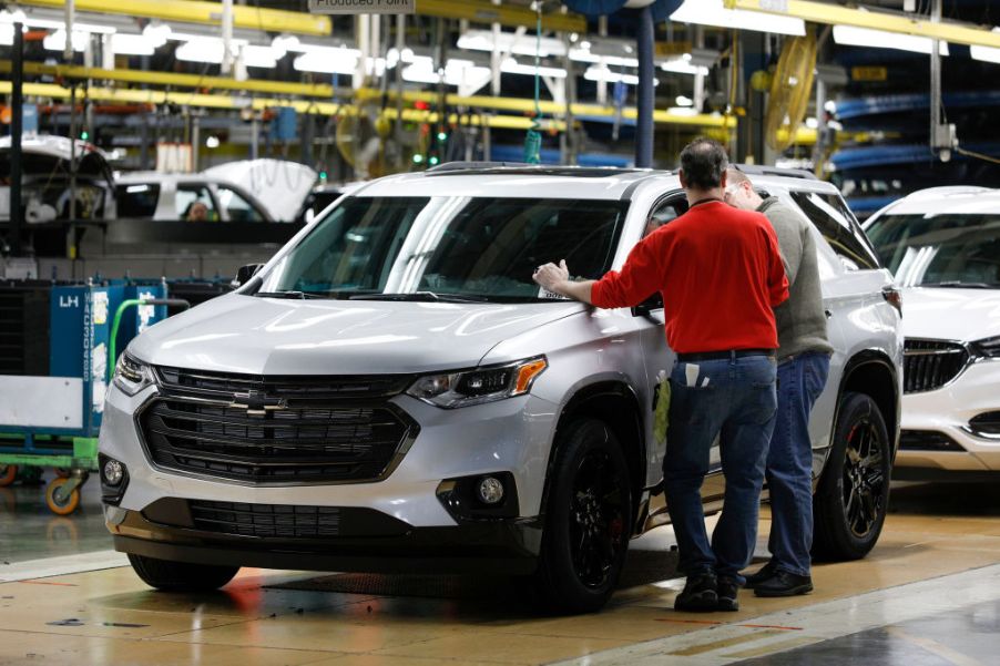 Workers assembling cars at a GM plant