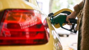 A motorist uses a pump as they re-fuel their car with unleaded petrol