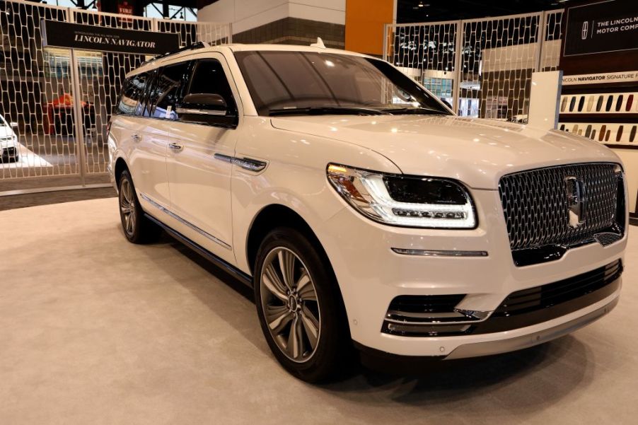 A white Lincoln Navigator on display at an auto show