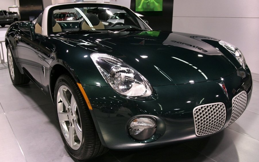 A green Pontiac Solstice parks on a stage.